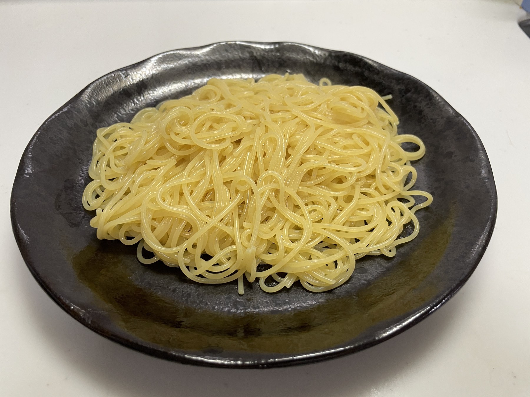 1.4 mm pasta after alkaline cooking, served on a black plate